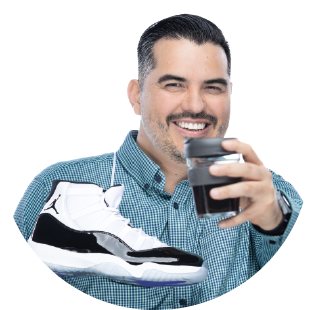 Alfonso Carmona holding a cup of coffee and a pair of Jordan 11 sneakers.